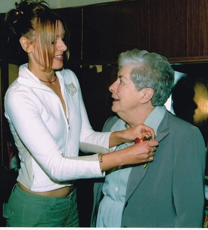 Erica fastening something to the shirt of her beautiful mum, Rosemary. By then, the polished, carefully curated Erica had learned to outrun her past, yet beneath it all she remained the same little girl, still searching for safety and belonging.
