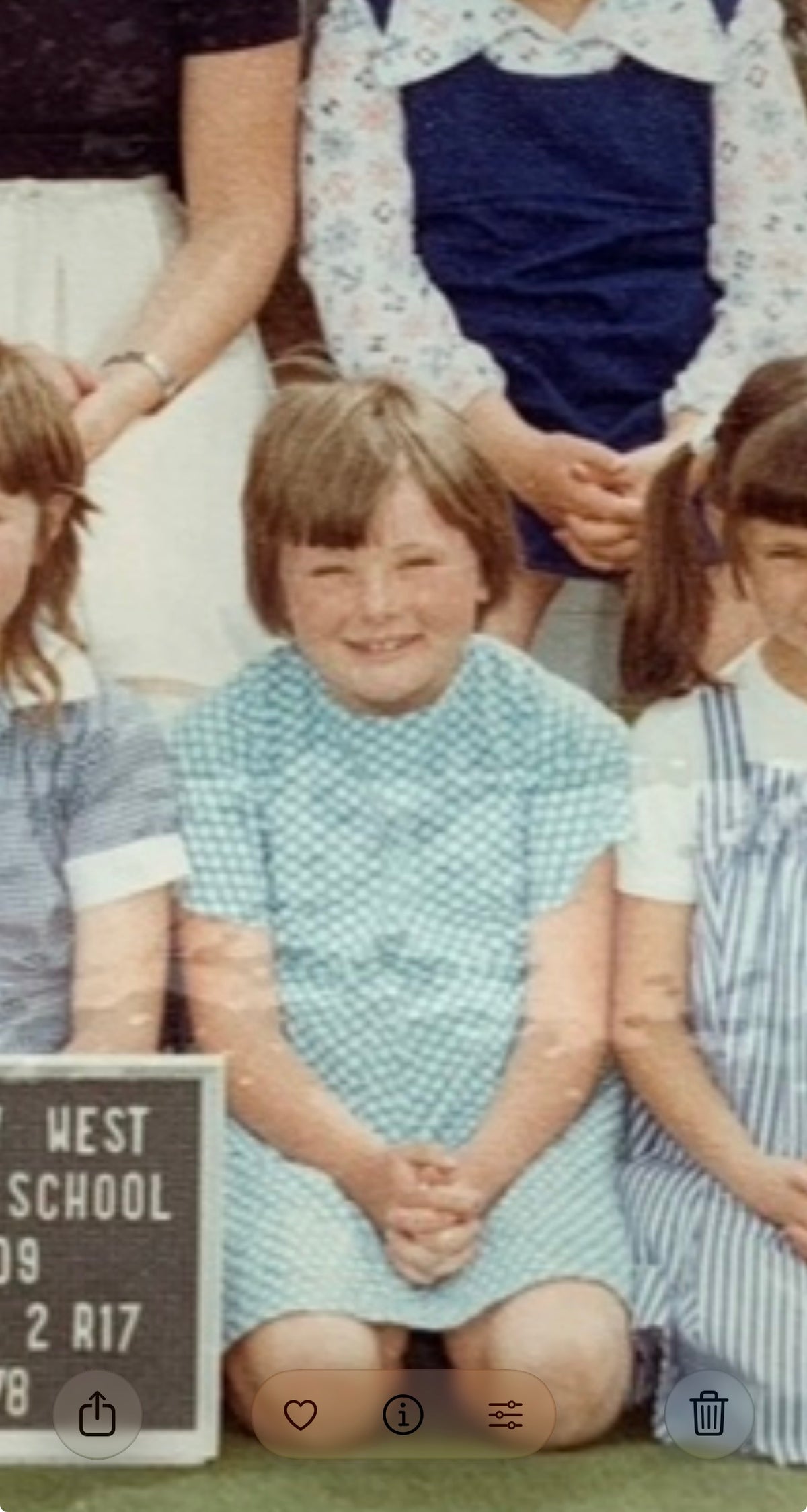 Erica in the blue dress her mum made by hand, with a haircut done at home too. It was a childhood of second-hand things, making do and creating what was needed, where care often appeared through the things Mum made herself.